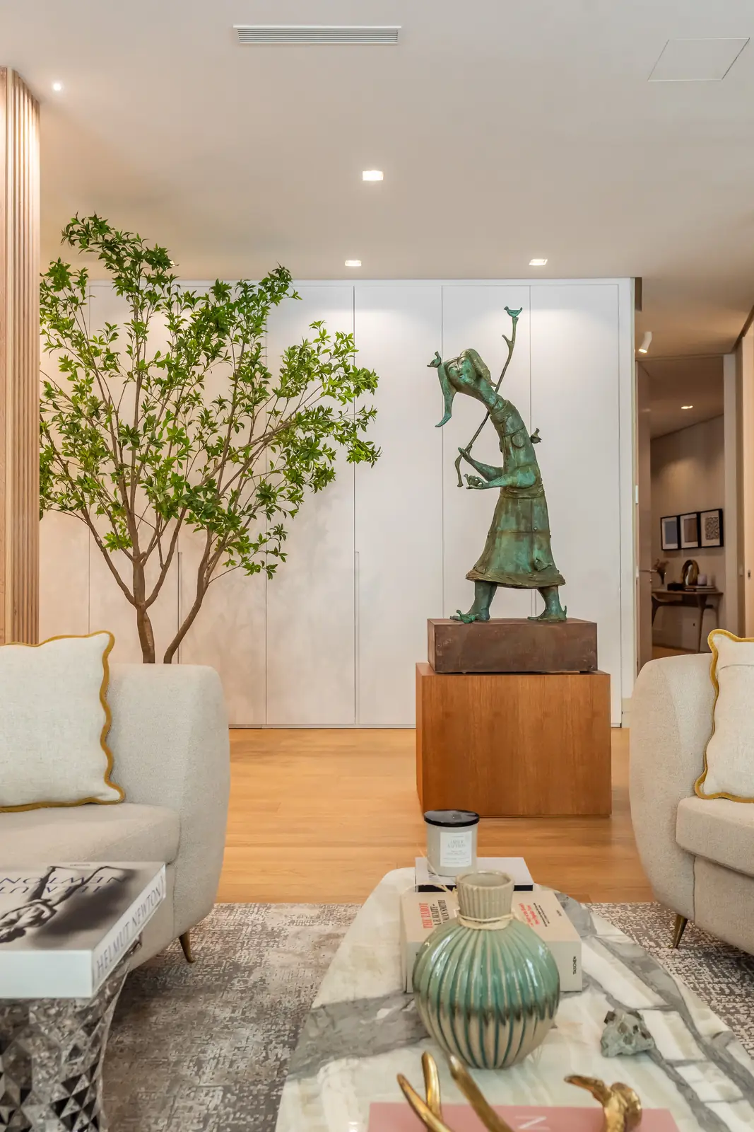 Salón decorado con butacas, escultura y mesa de centro de mármol