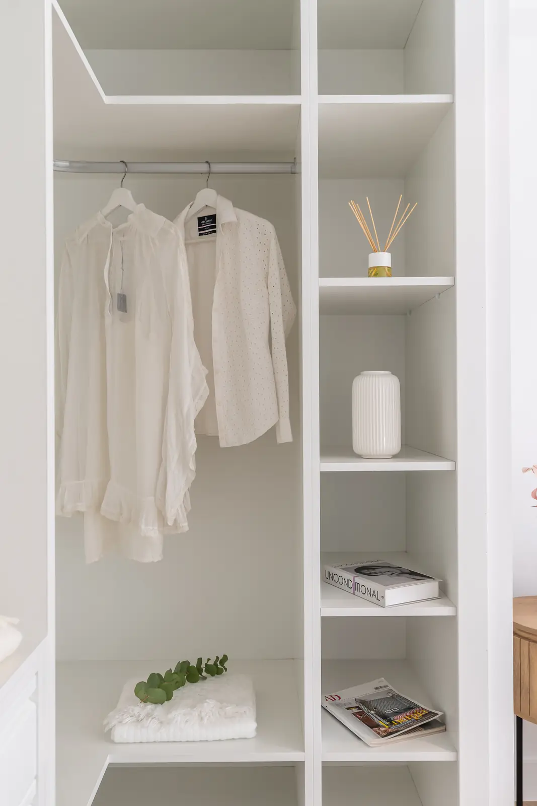 Vestidor con armario abierto, camisas y estanterías decoradas